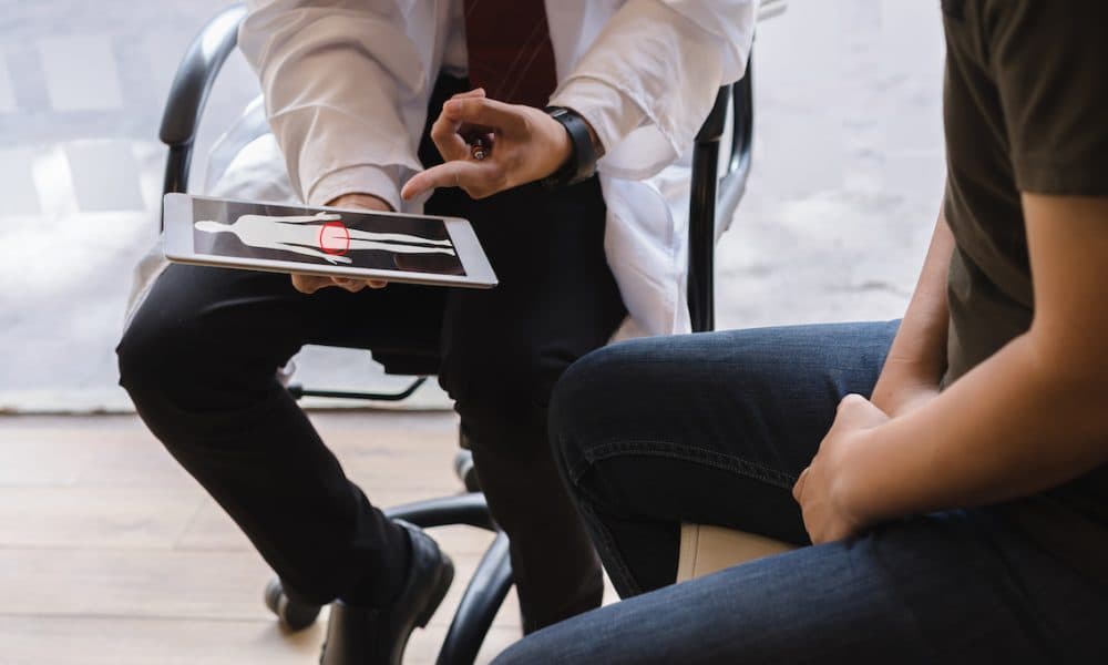 Male doctor and testicular cancer patient are discussing about testicular cancer test report. Testicular cancer and prostate cancer concept. New approach in cancer detection diagnostics cuts sepsis risk