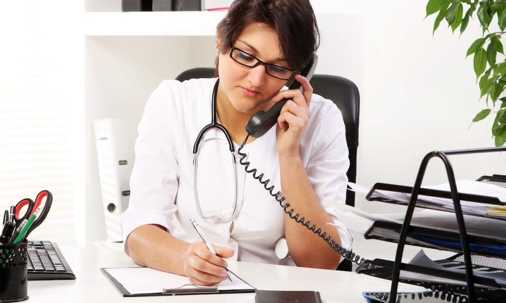 Young woman doctor talking by phone GP visits rising but video-conferencing growth remains flat