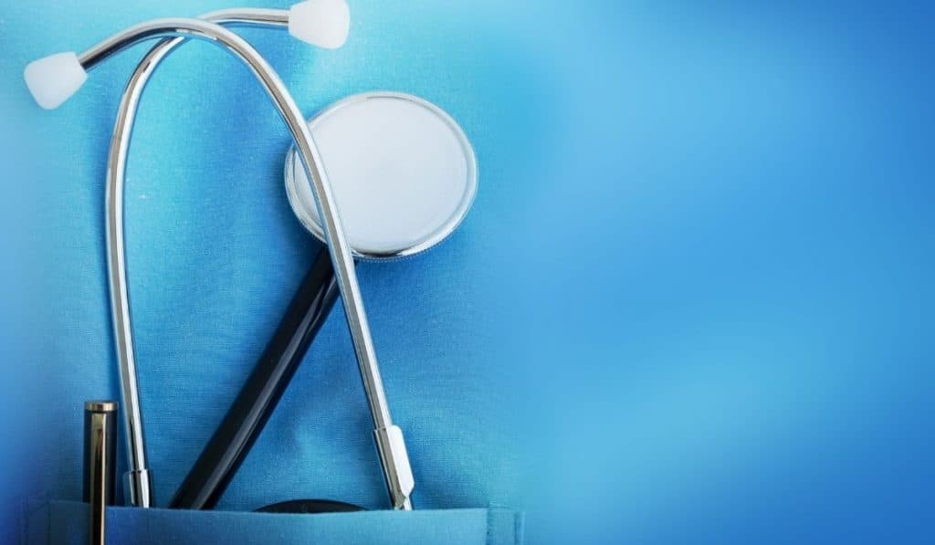 NHS blue overalls with a stethoscope tucked into the pocket to highlight an article about NHS carbon footprint reduction