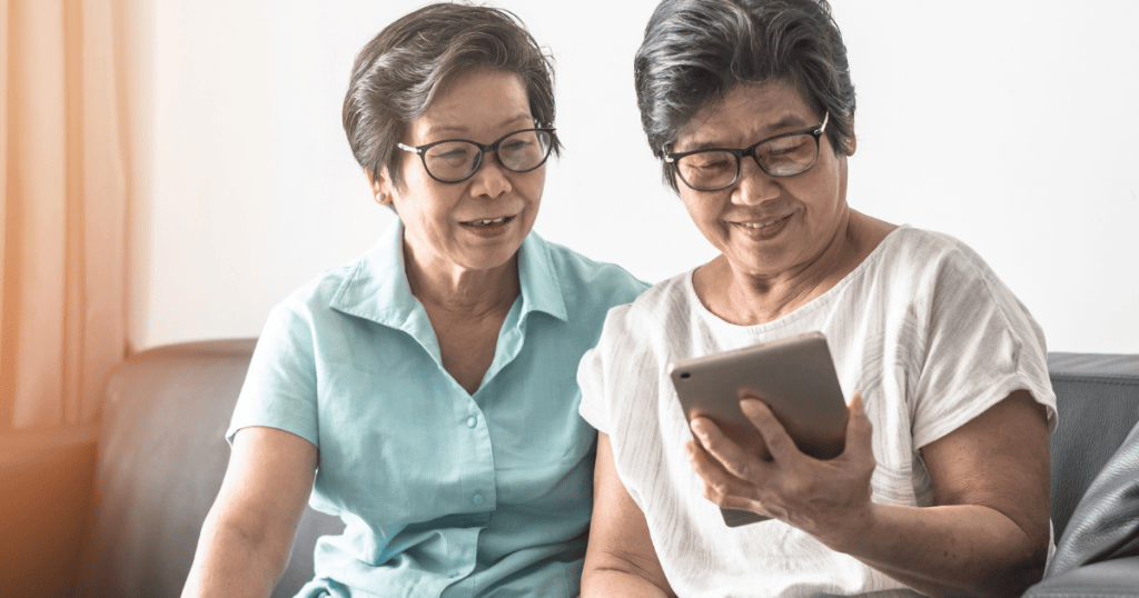 Two elderly people watching a tablet