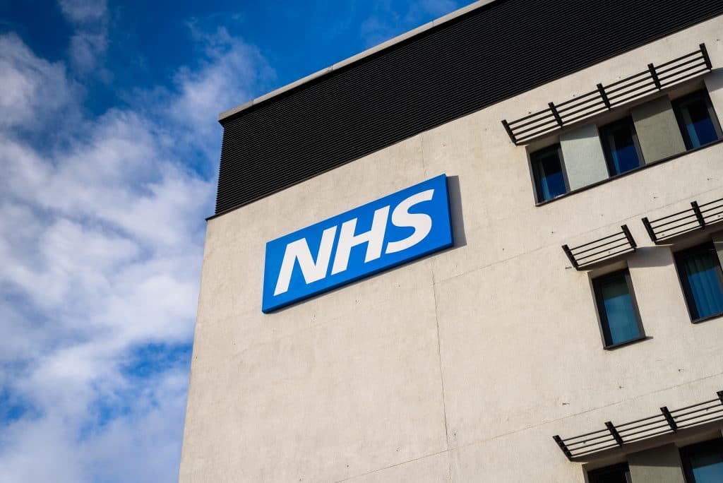 An NHS building against a blue