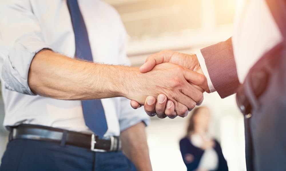 Businesspeople shaking hands iZafe set to acquire Pilloxa in medication compliance deal