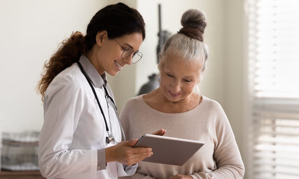 Happy doctor and senior patient use tablet at consultation Why I keep my mum in mind when designing clinical audit
