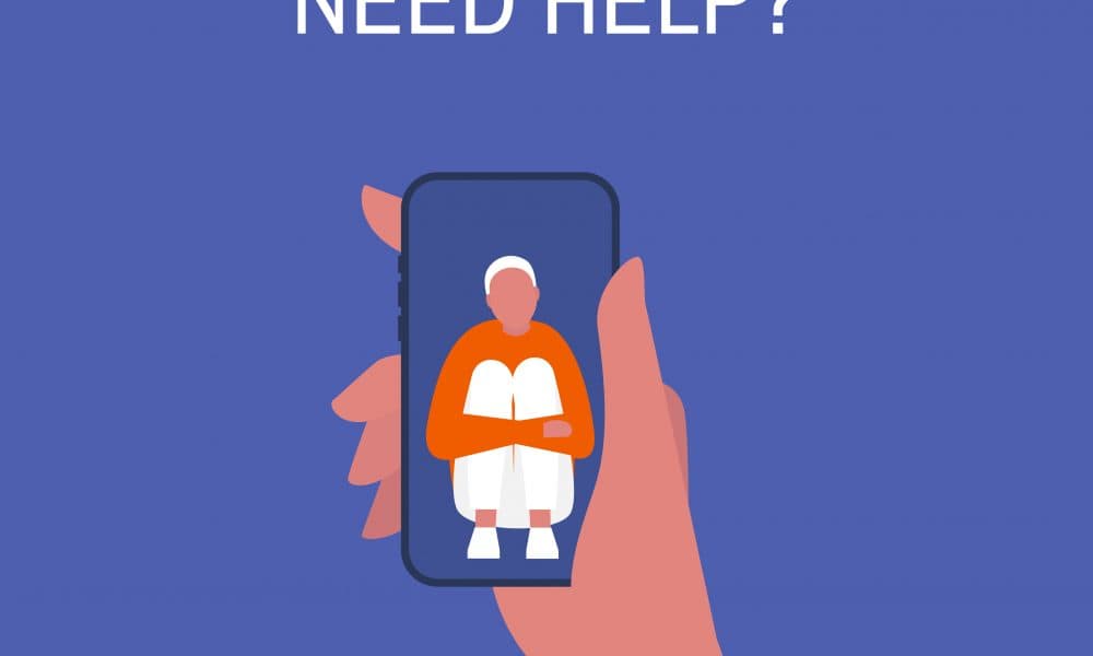 Crisis hotline. Need help? Hand holding a smartphone. New technologies. Therapy. Appointment. Mental health. Millennials. Young lonely male character hugging his knees. “We must look to digital mental health solutions as part of future treatment plans”