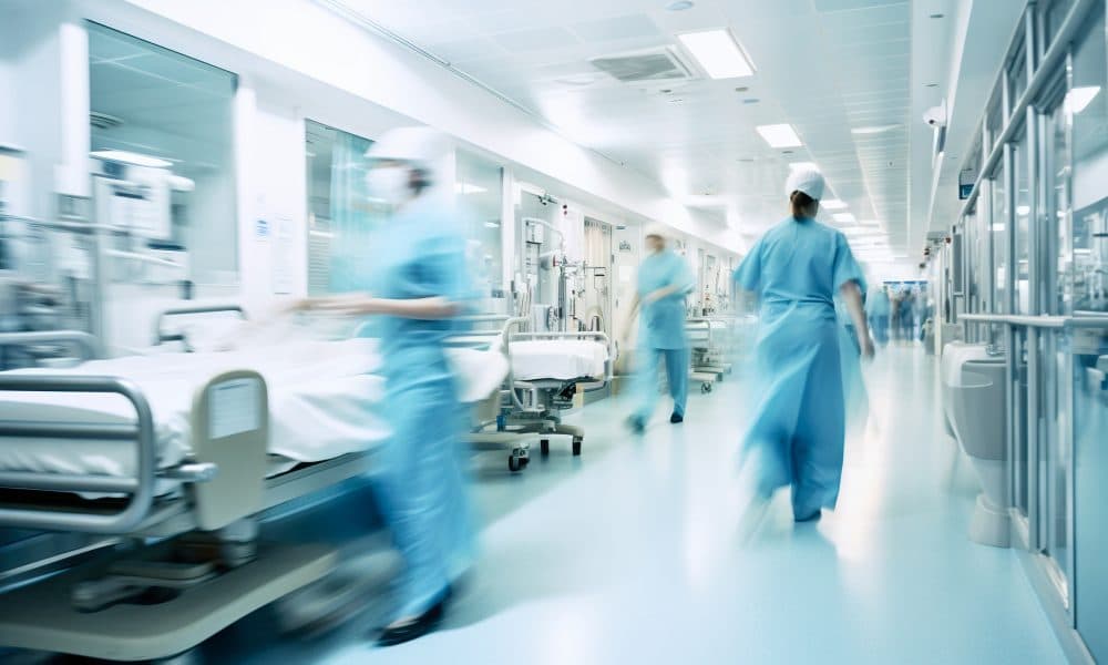 Long exposure blurred motion of medical doctors and nurses in a hospital ward wearing blue aprons, walking down a corridor – Generative AI Pathpoint eTrauma launches at Medway NHS Foundation Trust