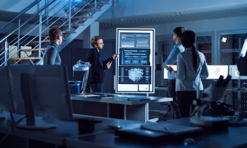 Project Manager Does Motivational Presentation or Team of Electronics Development Engineers, he Uses Digital Whiteboard with Neural Network, AI and Machine Learning. AI harnesses tumour genetics to predict treatment response