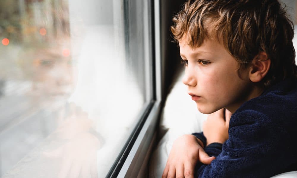 Boy stays home bored by school closings due to covid pandemic. Rising respiratory illnesses expose children to dual health threats