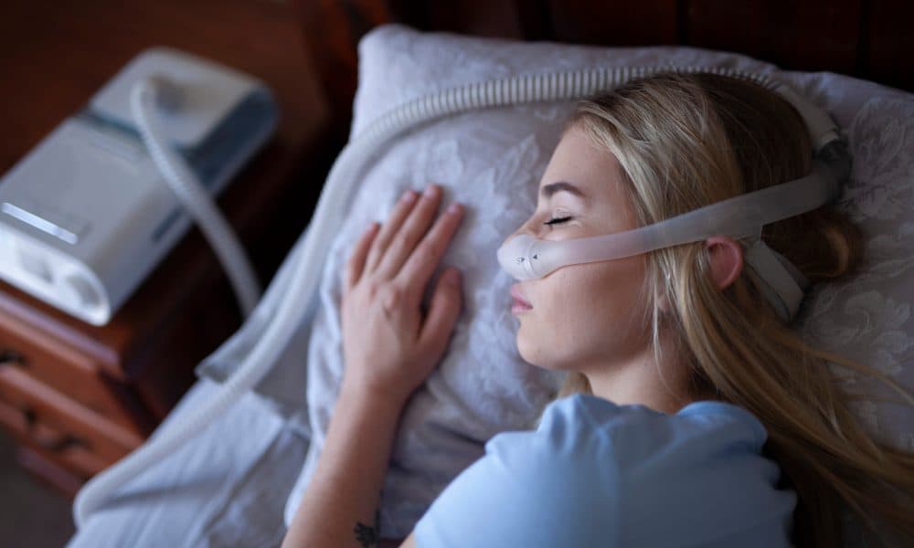 Young person, sleeping with cpap machine. Study identifies first drug therapy for sleep apnoea