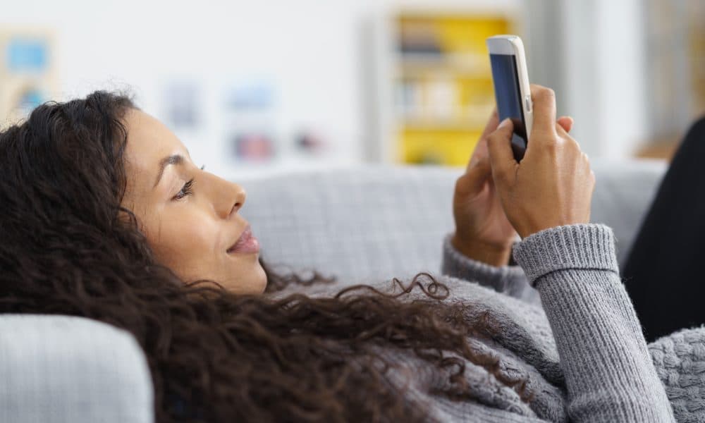 Woman,Lying,On,The,Sofa,While,Writing,A,Text,Message AI partnership targeting non-attendance forecasted to save trust £28m annually