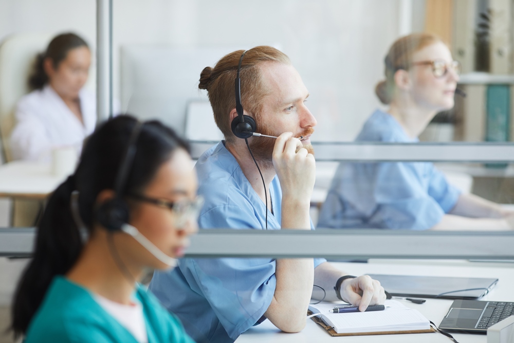 group-operators-headphones-sitting-their-workplaces-working-medical-call-center NHS call handler resignations rise amid trauma and stress