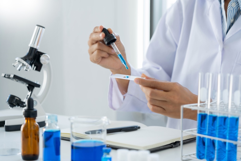Scientist wear lab coat and protective wear are working with research or doing investigations with test tubes in experiment, Laboratory and development concept The Hidden Role of Chemical Analysis in Patient Safety
